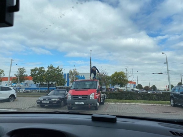 «Становится модным залезать на чужие машины». Девушка забралась на крышу эвакуатора в Минске